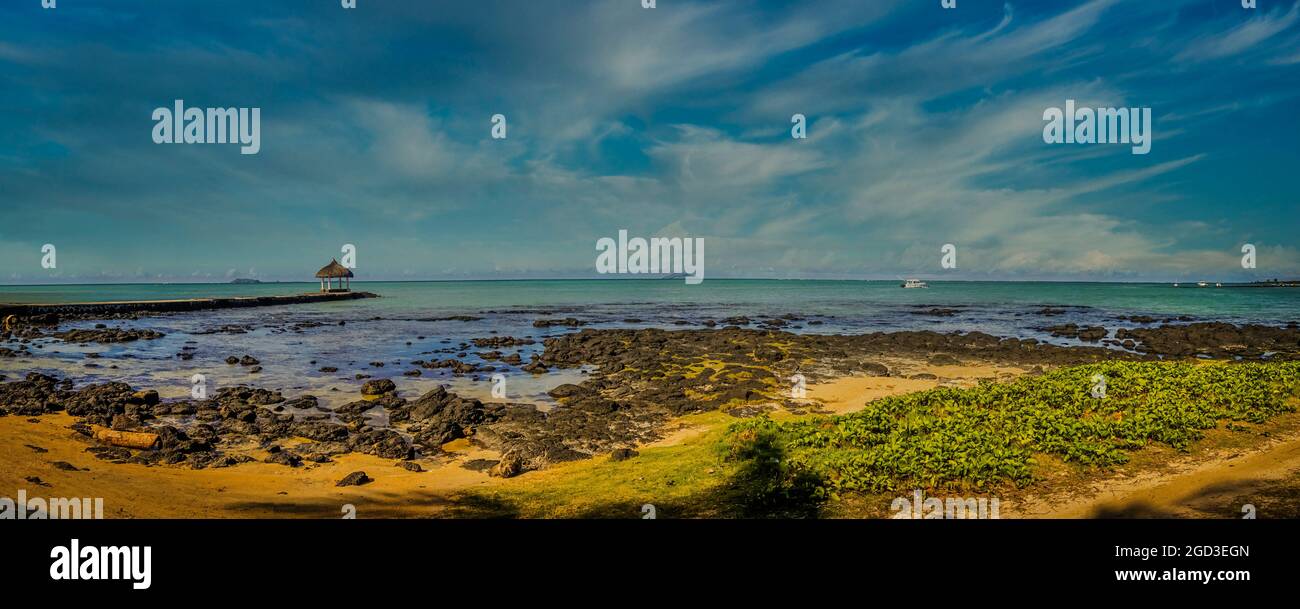 Vista panoramica di una splendida baia e di un pontile che conduce ad un chiosco che si affaccia sul mare sull'isola di Mauritius Foto Stock