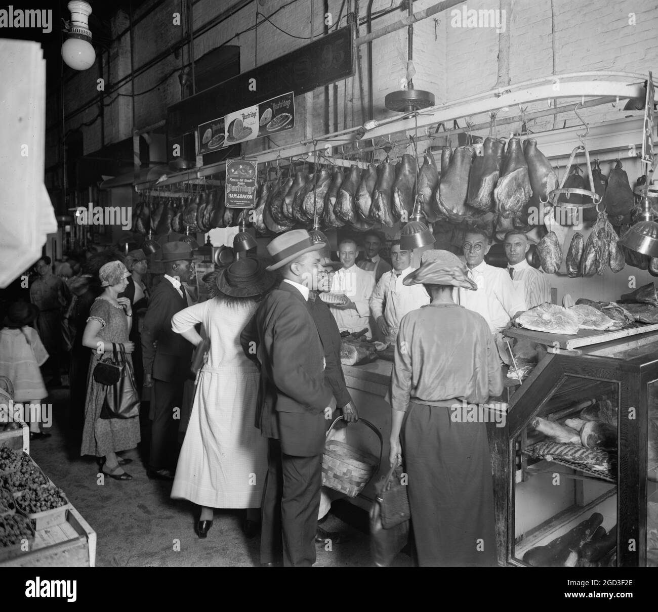 Clienti in un mercato della carne all'inizio del XX secolo circa tra il 1910 e il 1920 Foto Stock