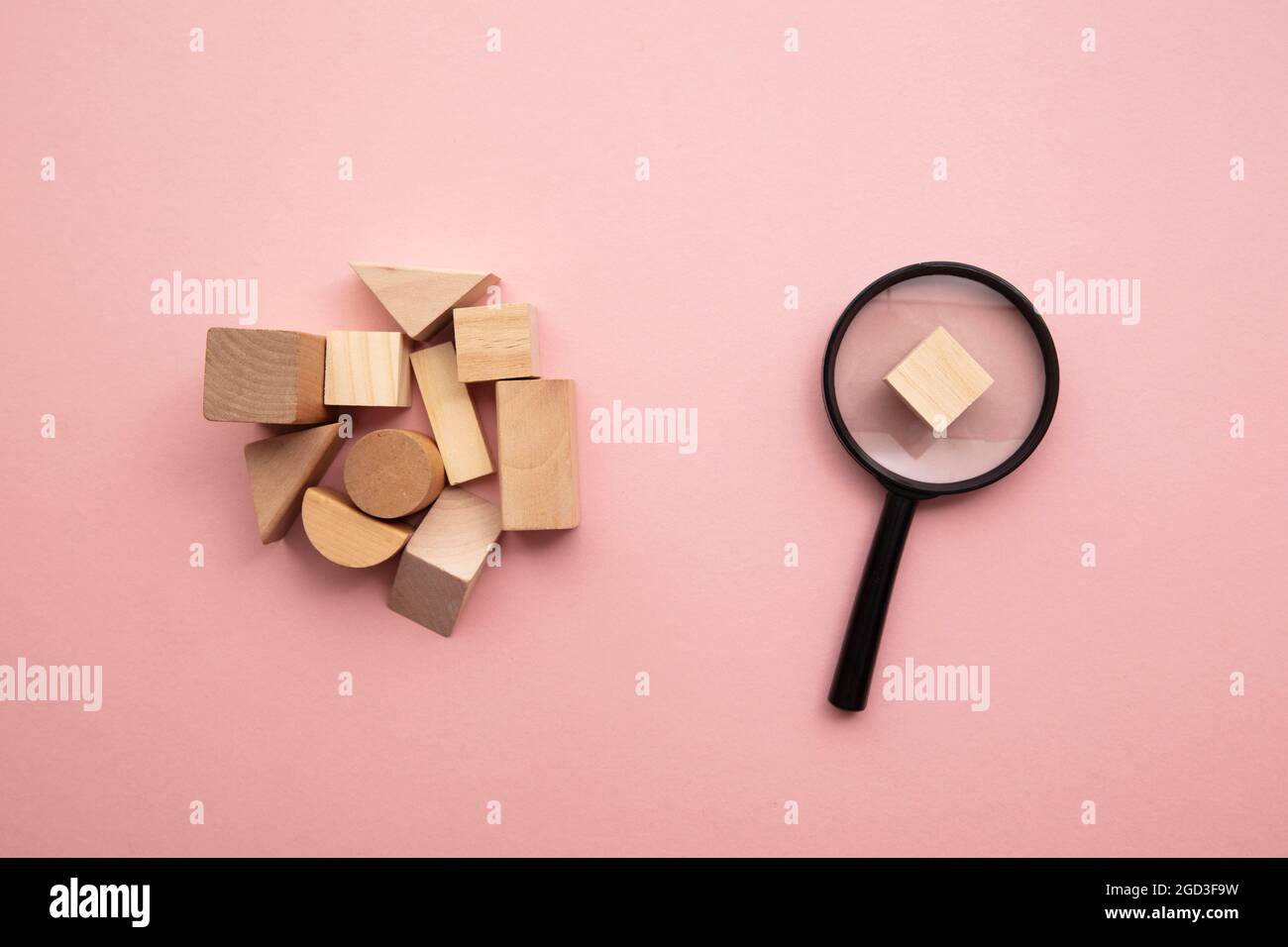 Lente di ingrandimento con una selezione di blocchi di legno di forma diversa Foto Stock