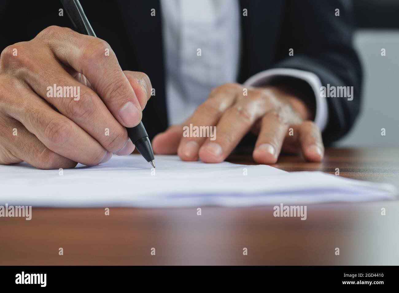 Closeup firma del responsabile della mano sul documento, Firma l'azienda di contatto nel concetto dell'ufficio Foto Stock