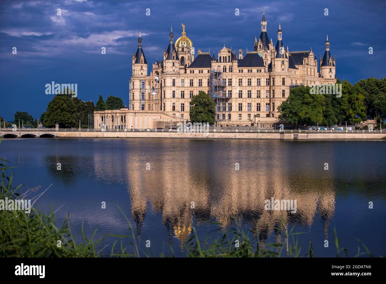 Schwerin, Germania. 10 agosto 2021. Le nuvole scure passano sopra il castello di Schwerin dopo una tempesta di tuoni. La sede del parlamento statale del Meclemburgo-Pomerania occidentale si riflette nel lago del castello. Credit: Jens Büttner/dpa-Zentralbild/dpa/Alamy Live News Foto Stock