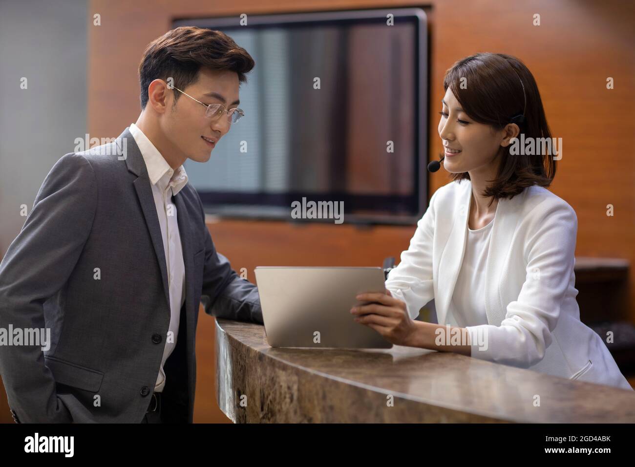 La receptionist dell'hotel parla con il cliente Foto Stock