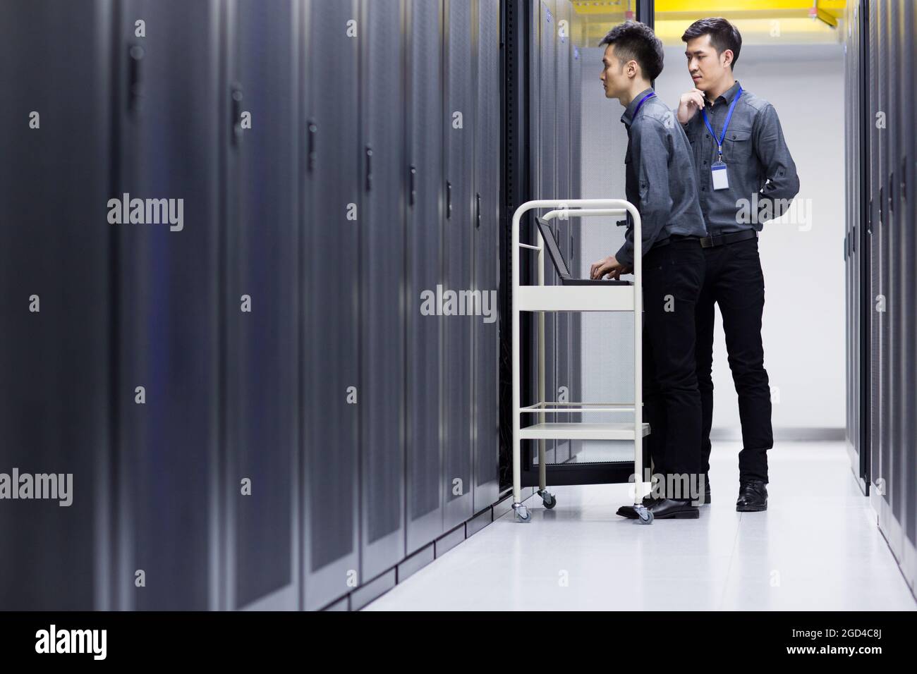 Tecnici che eseguono la manutenzione nella sala computer Foto Stock