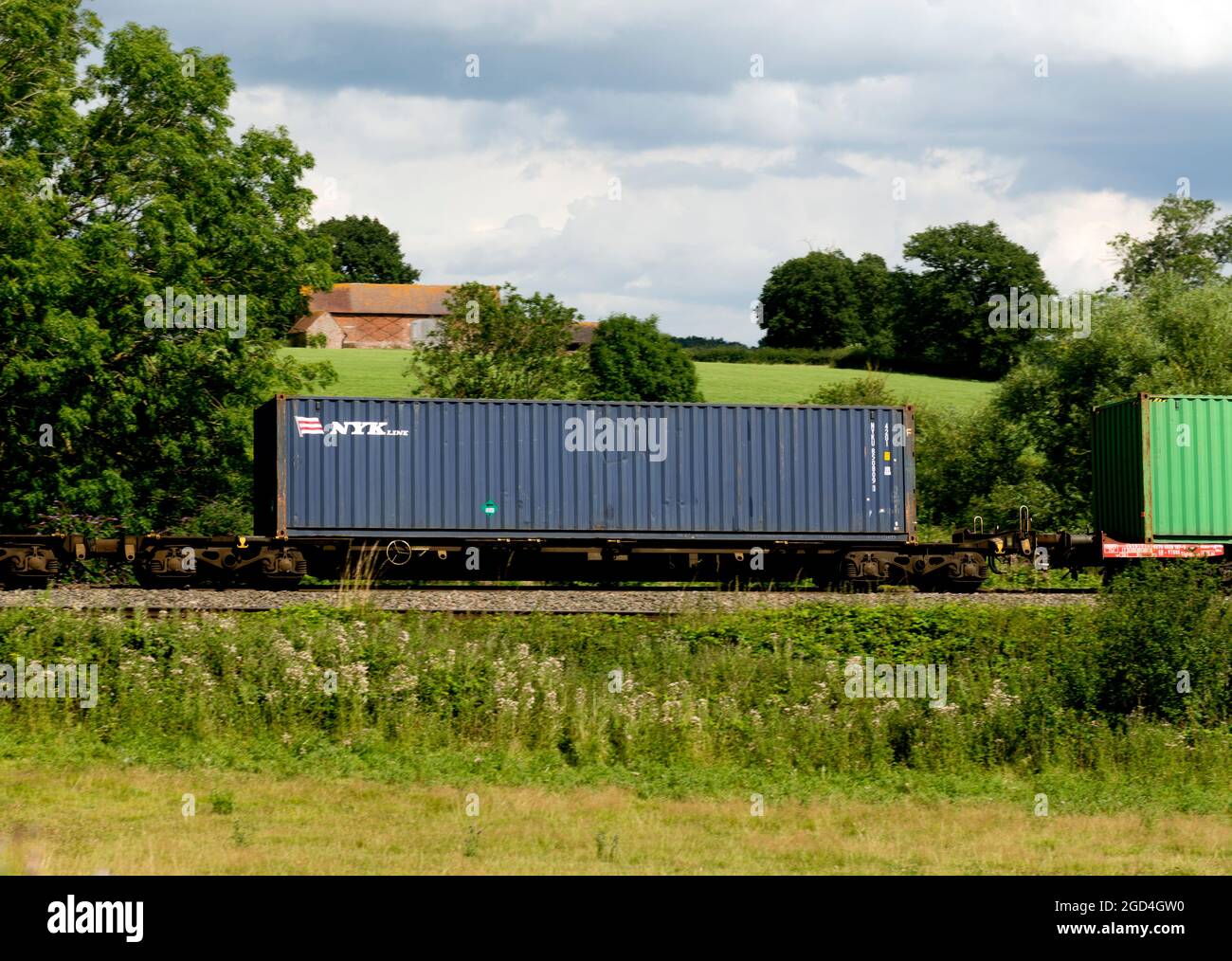 Contenitore per spedizioni NYK Line su un treno freightliner, Warwickshire, Regno Unito Foto Stock