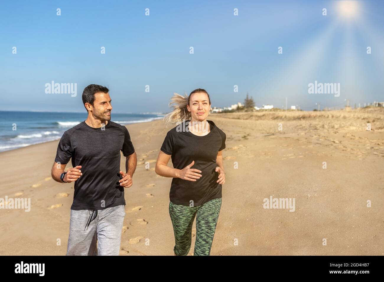 Un allenatore di fitness e un cliente, una donna europea, scuotono le mani. Felice e soddisfatto. Sullo sfondo del mare in estate. Foto Stock