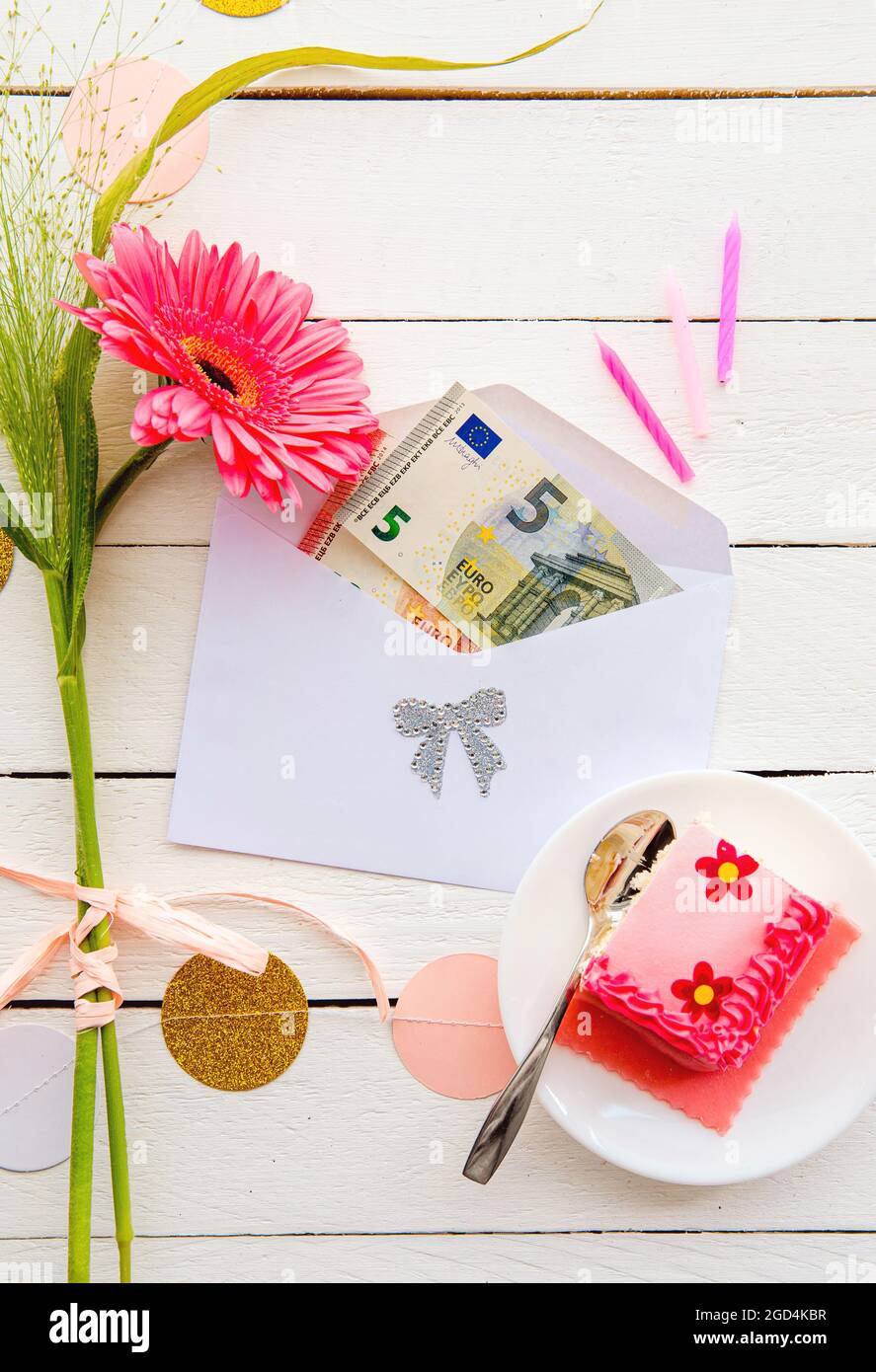 Euro soldi come concetto di regalo di compleanno. Banconote in euro  all'interno della busta, decorate con torta e fiori Foto stock - Alamy