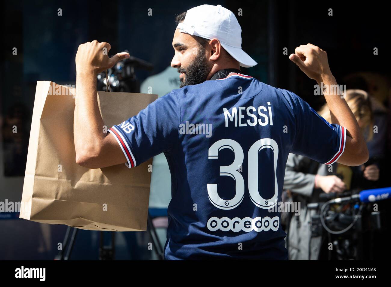 Parigi, Francia. 11 Agosto 2021. Un sostenitore mostra una maglia del calciatore argentino Lionel messi del PSG, che ha appena acquistato presso il negozio della squadra di calcio Paris-Saint-Germain (PSG) sul viale degli Champs Elysees a Parigi il 11 agosto 2021. Messi ha firmato il 10 agosto 2021 un accordo biennale con PSG con l'opzione di un anno supplementare. Il 34-year-old indosserà il numero 30 a Parigi, il numero che ha avuto quando ha cominciato la sua carriera professionale a Barca. Foto di Raphael Lafargue/ABACAPRESS.COM Credit: Abaca Press/Alamy Live News Foto Stock
