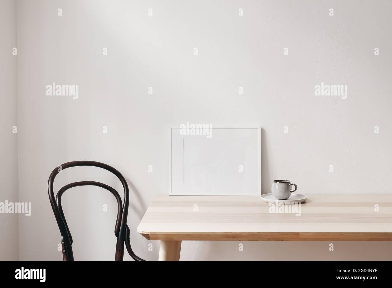 La colazione è ancora scena di vita. Tazza di caffè, libri e bianco orizzontale vuoto cornice mockup su tavola di legno. Elegante spazio di lavoro, ufficio a casa Foto Stock