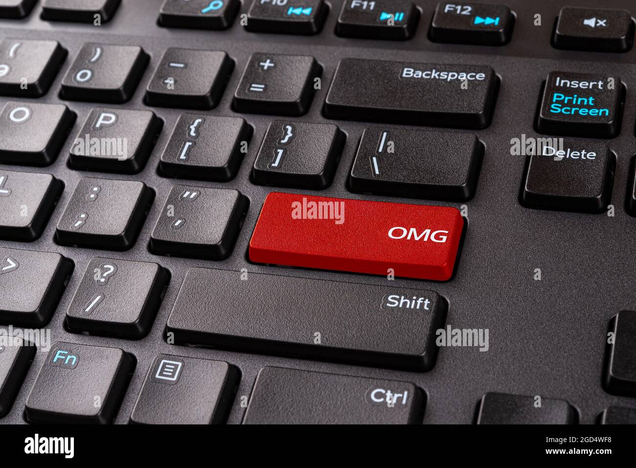 Tasto rosso OMG su una tastiera nera del pc. Tastiera desktop con pulsante slang del gamer OMG. Tasto Enter con OH mio dio abbreviazione di gioco. Acronimi della chat del giocatore. Foto Stock
