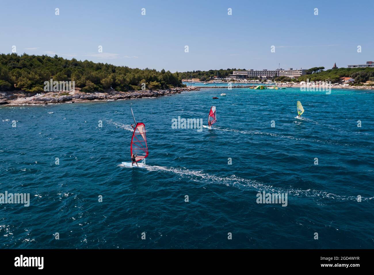 sport acquatici: windsurf con vele colorate in acque blu oceaniche Foto Stock