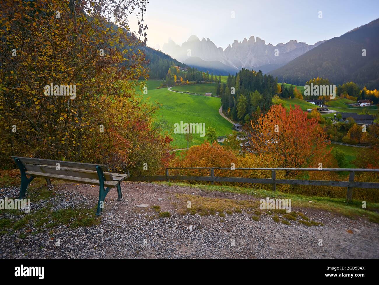 Panchina con vista sul villaggio di Santa Maddalena (St Magdalena) con le montagne dolomitiche sullo sfondo, Val di Funes, Trentino Alto Adige, Ita Foto Stock