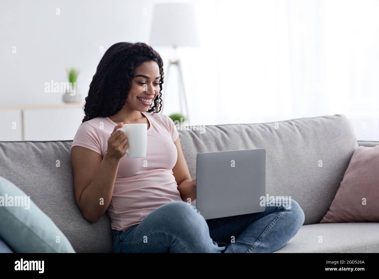 Nuova normalità, epidemia di covid-19, lavoro a casa, lezione remota, studio e istruzione, videochiamata. Allegra millennial afroamericana dama che scrive sul lapto Foto Stock