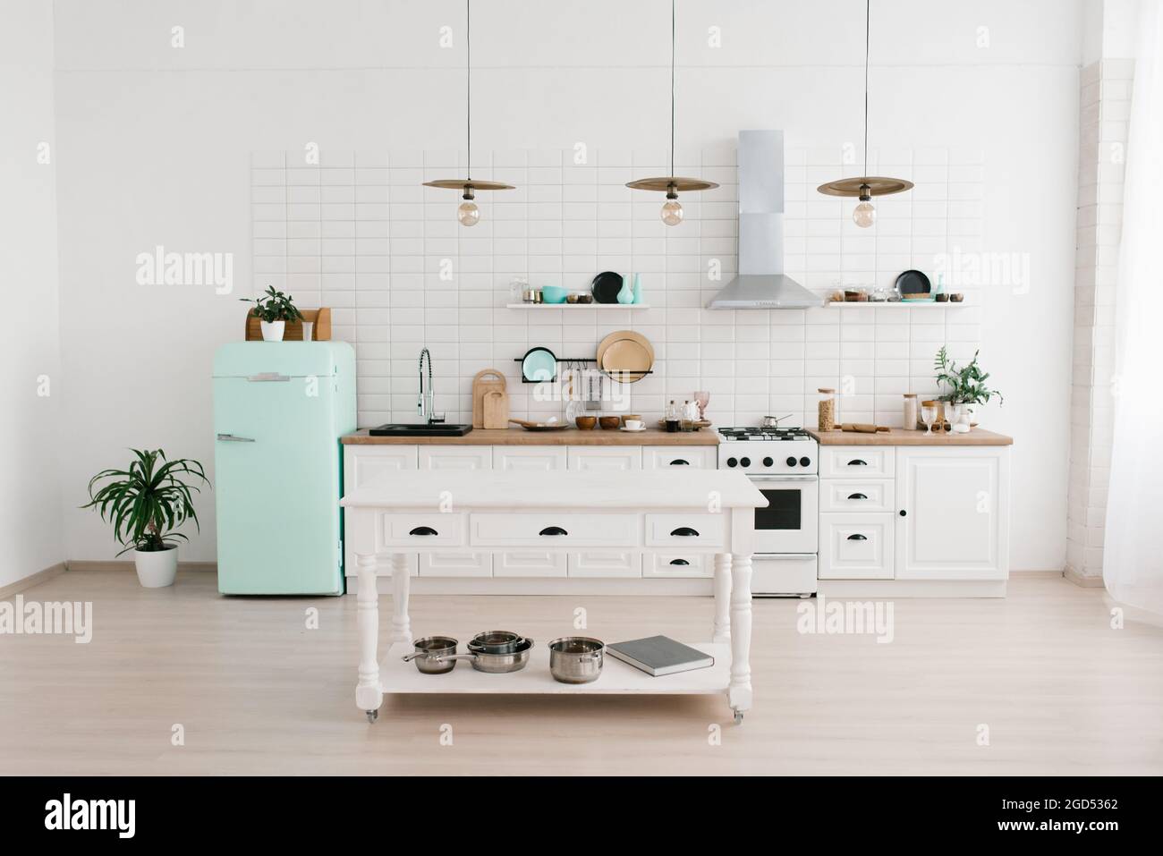 La luminosa cucina in stile scandinavo dispone di un frigorifero color  menta. Tavolo da cucina in legno con piatti Foto stock - Alamy