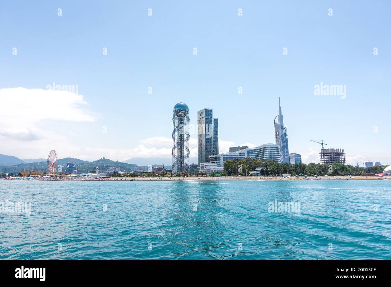 Batumi, Georgia - 2 luglio 2021: Costa di Batumi. Popolare località georgiana sul Mar Nero. Vista panoramica della ruota panoramica, della torre alfabetica, dei grattacieli e della spiaggia dal mare. Foto Stock