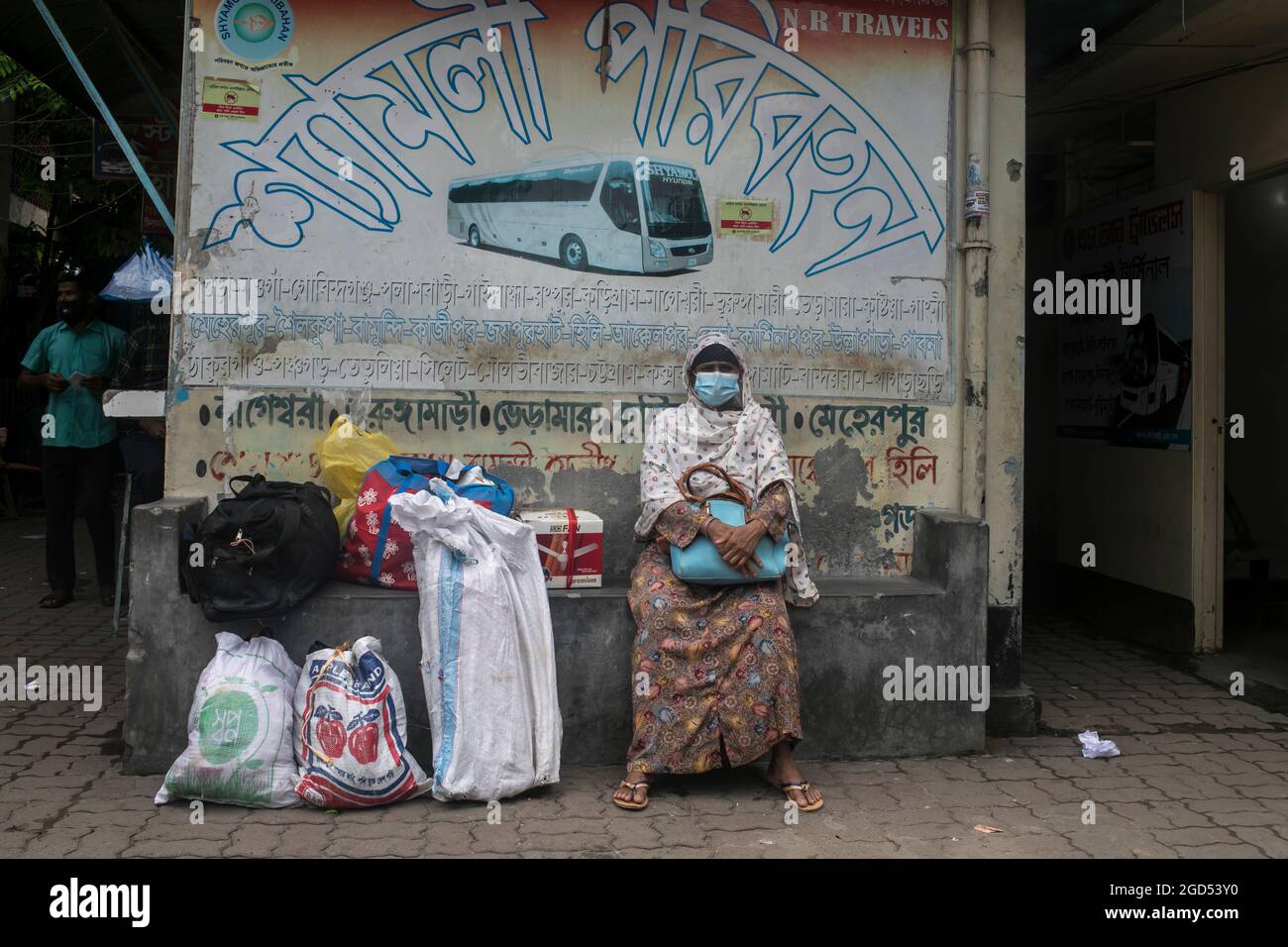 Dhaka, Bangladesh. 11 Agosto 2021. Una donna attende l'autobus al terminal degli autobus di Gottoli per raggiungere la sua città natale a Dhaka, dopo la riapertura dei trasporti pubblici.i trasporti pubblici hanno ripreso in tutto il paese dopo 19 giorni, nel timore di un ulteriore aumento di morti e infezioni di Covid-19. Credit: SOPA Images Limited/Alamy Live News Foto Stock