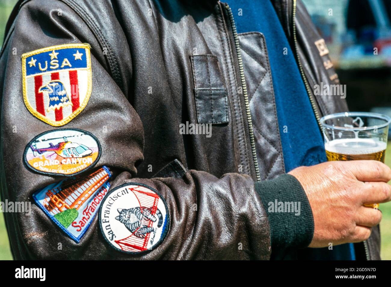 American patriot bere birra e indossare giacca bombardiere in pelle con decalcomanie sulla manica, Londra, Regno Unito Foto Stock