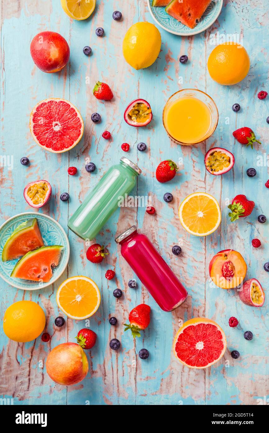 Variazione di frullati e bevande rinfrescanti con frutta fresca per l'estate calda su sfondo blu Foto Stock