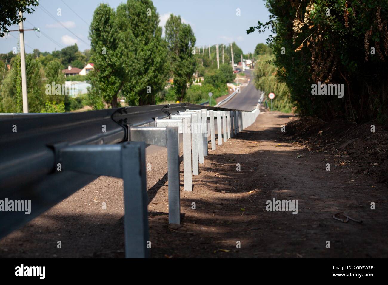 riflettori stradali rossi lungo la strada. recinzioni stradali in metallo di tipo barriera, primo piano. Sicurezza stradale e stradale. Vernice riflettente sul cartello. Barriera mediana Foto Stock