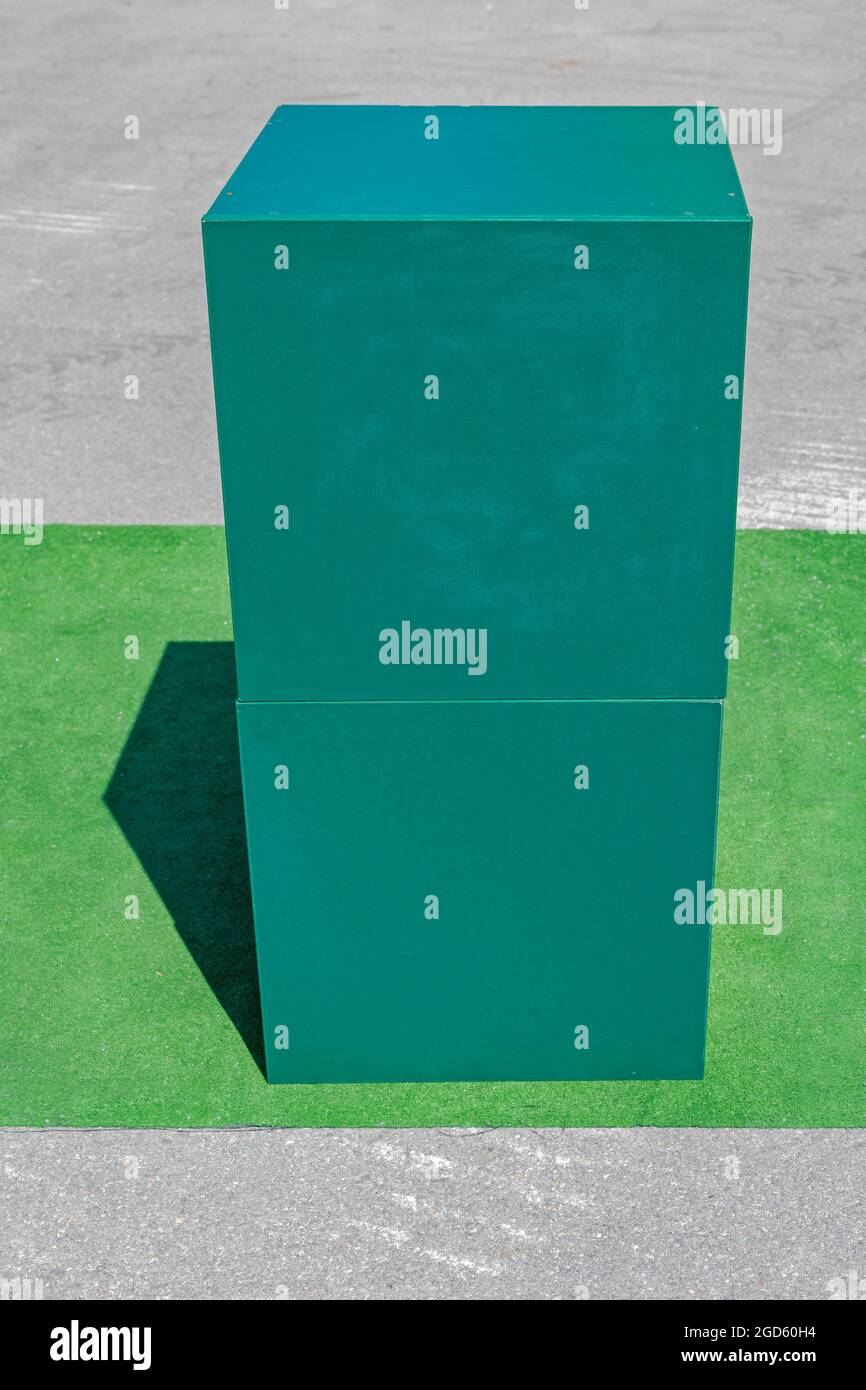 Due scatole verdi impilate su un pezzo di Astro Turf Foto Stock