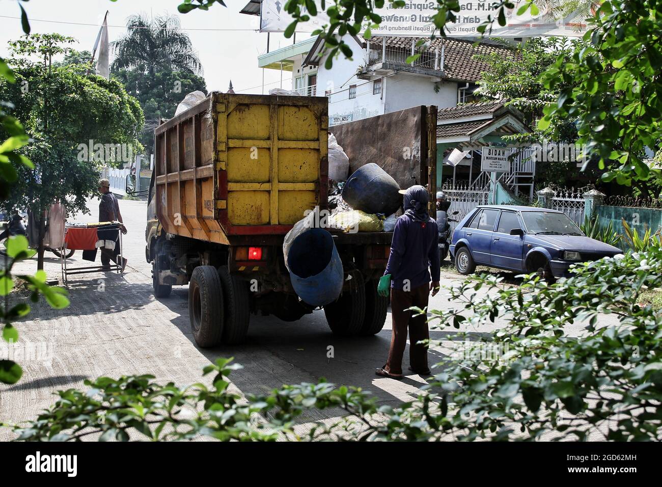 Bandung, Giava Occidentale, Indonesia. Un uomo spazzatura è vicino a un camion della spazzatura Foto Stock