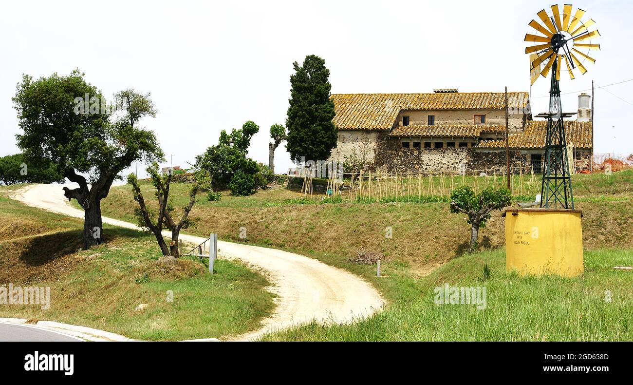 Fattoria con mulino di estrazione dell'acqua gialla in provincia di Girona, Catalunya, Spagna, Europa Foto Stock