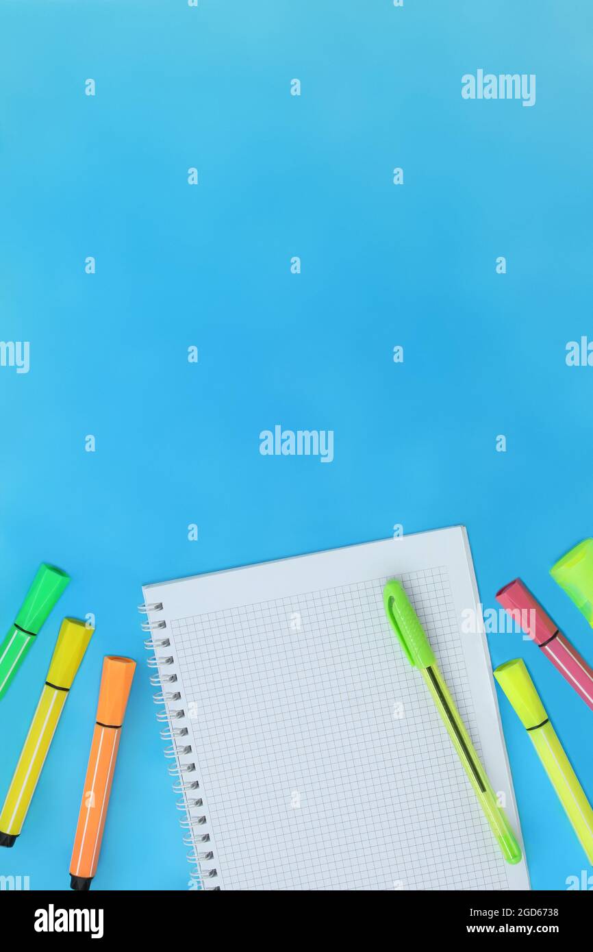 Ritorno a scuola. Concetto di istruzione. Marcatori. Notebook a scacchi con penna per testo su sfondo blu con spazio vuoto Foto Stock