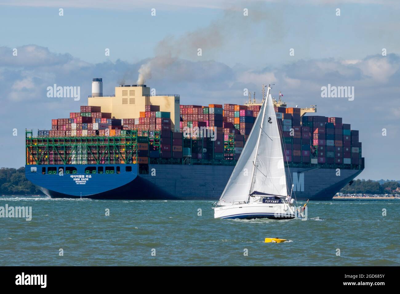 grande container nave, container nave e yacht, yacht che passa grande nave, yachting nel solent, yacht nel canale di spedizione. vela in percorso di grande nave Foto Stock