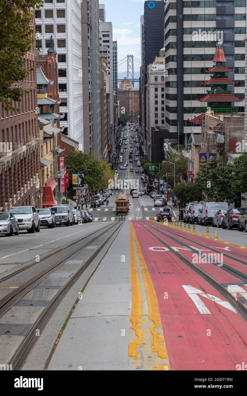 Guardando lungo le pendici di California Street a San Francisco verso il ponte della baia. Torre del ponte può ape vista tra gli edifici. Foto Stock