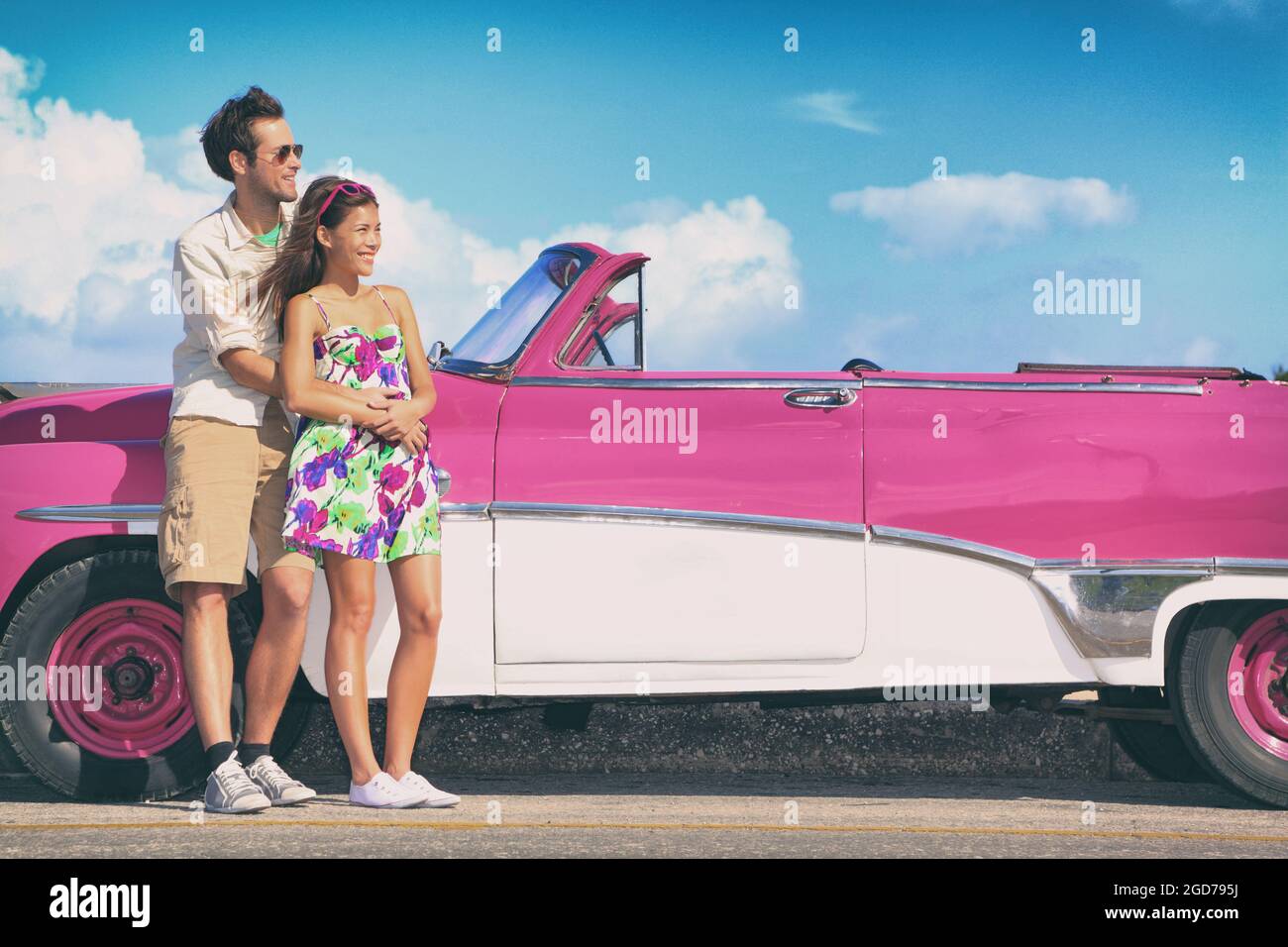 Coppia guida auto rosa vintage in estate viaggio su strada divertente. Foto Stock