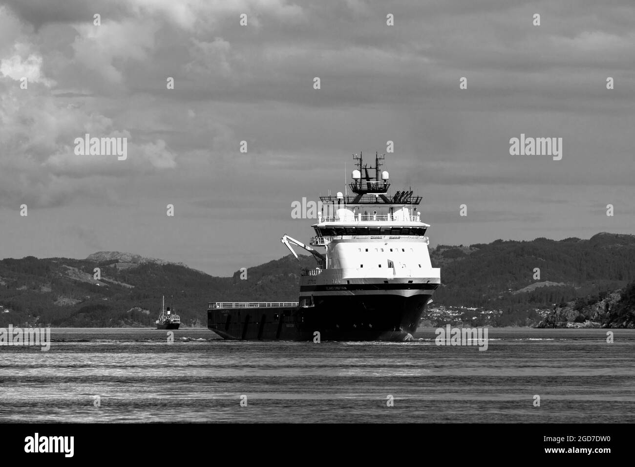 Offshore PSV piattaforma fornitura nave Isola Chieftain a Byfjorde, al largo del porto di Bergen, Norvegia. in background Foto Stock