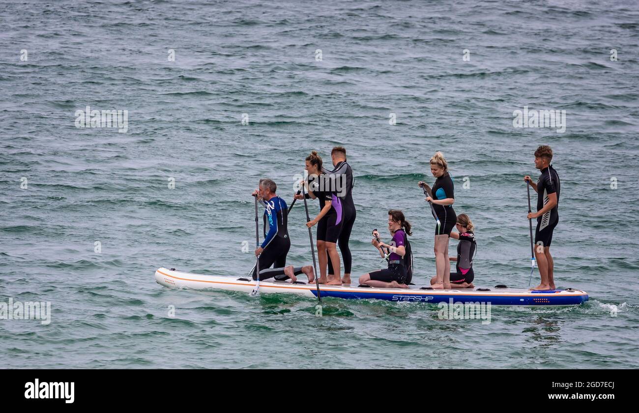 Otto persone a bordo di una singola pagaia o n il mare a St Ives, Cornovaglia, Regno Unito, il 2 agosto 2021 Foto Stock