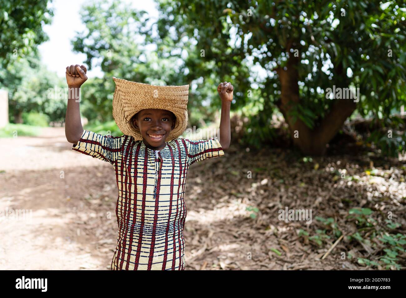 Divertente ragazzo nero africano con un grande sorriso sul viso, con un  cappello oversize, con pugni in segno di trionfo Foto stock - Alamy