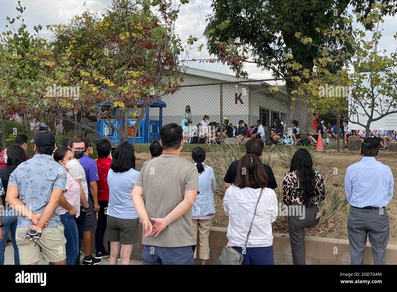 La gente guarda mentre gli studenti arrivano per il primo giorno di scuola alla scuola elementare di Brightwood, mercoledì 11 agosto 2021, a Monterey Park, Calif. Foto Stock