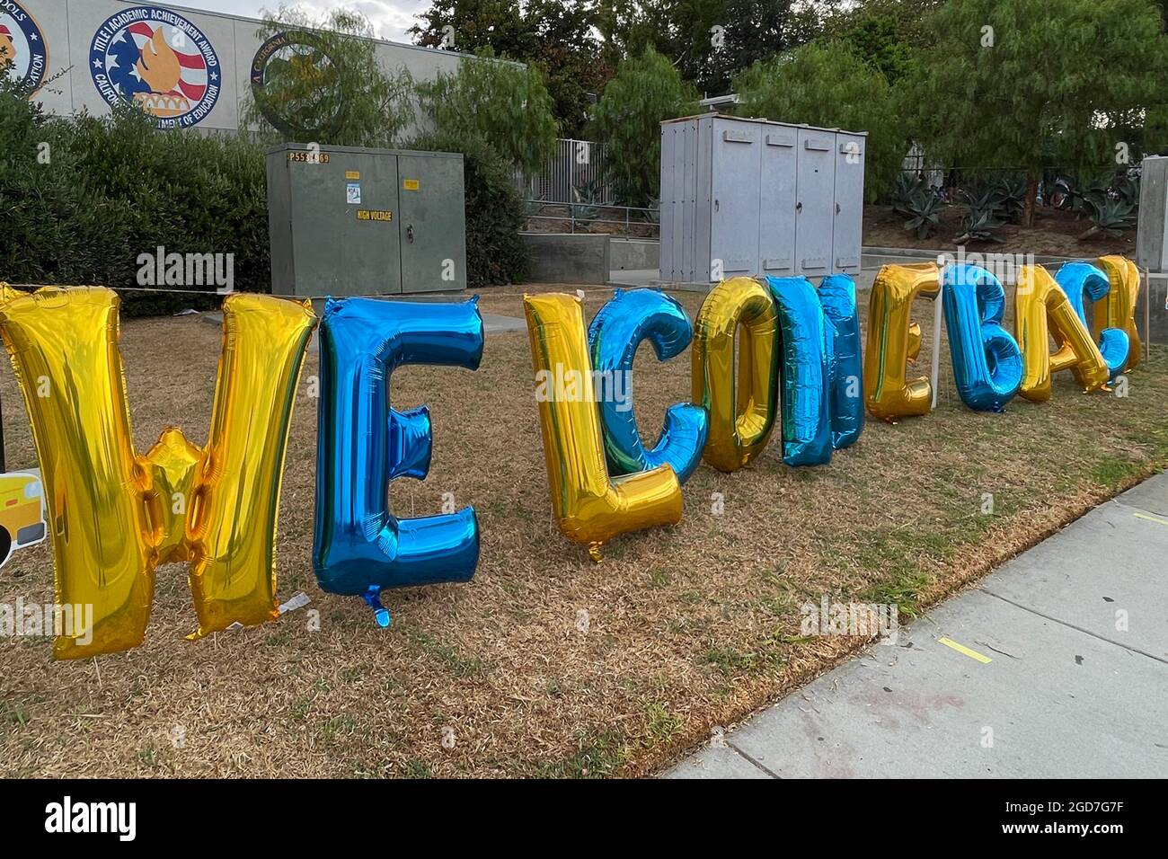 La gente guarda mentre gli studenti arrivano per il primo giorno di scuola alla scuola elementare di Brightwood, mercoledì 11 agosto 2021, a Monterey Park, Calif. Foto Stock