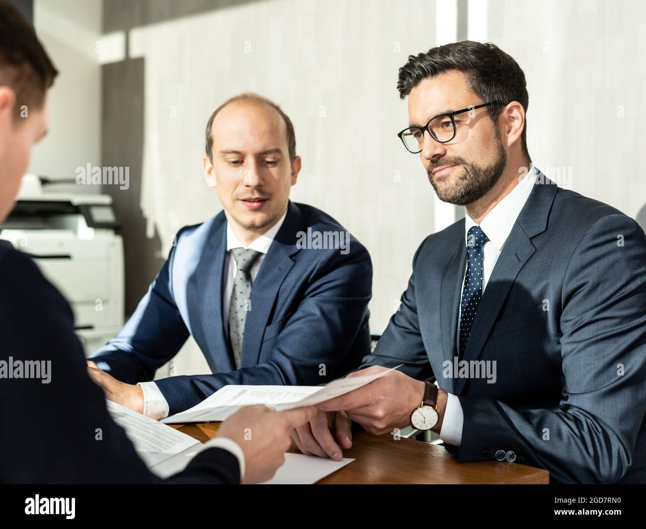 Primo piano di contratto di firma di uomo d'affari, donna che scrive la carta alla scrivania con la penna e leggendo i libri al tavolo con il documento di modulo di affari di base Foto Stock