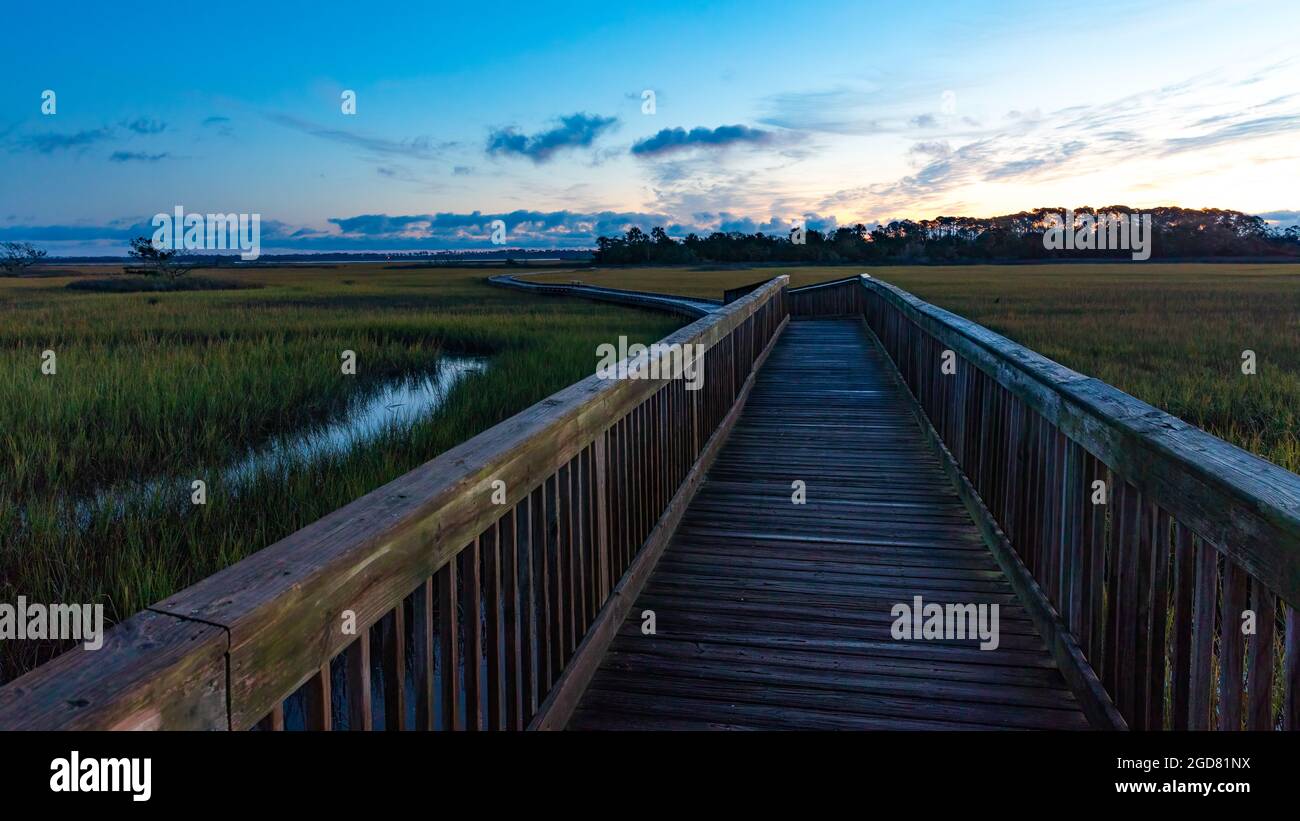 Alba sulla passerella sulla palude di acqua salata. Foto Stock