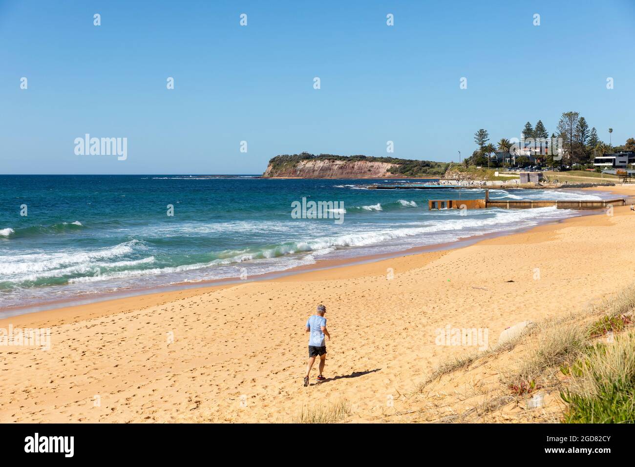 Spiaggia di Collaroy a Sydney in un giorno d'inverno, l'uomo scherza ed esercizi da solo durante il blocco del covid 19 Greater Sydney causato dal ceppo delta del virus Foto Stock