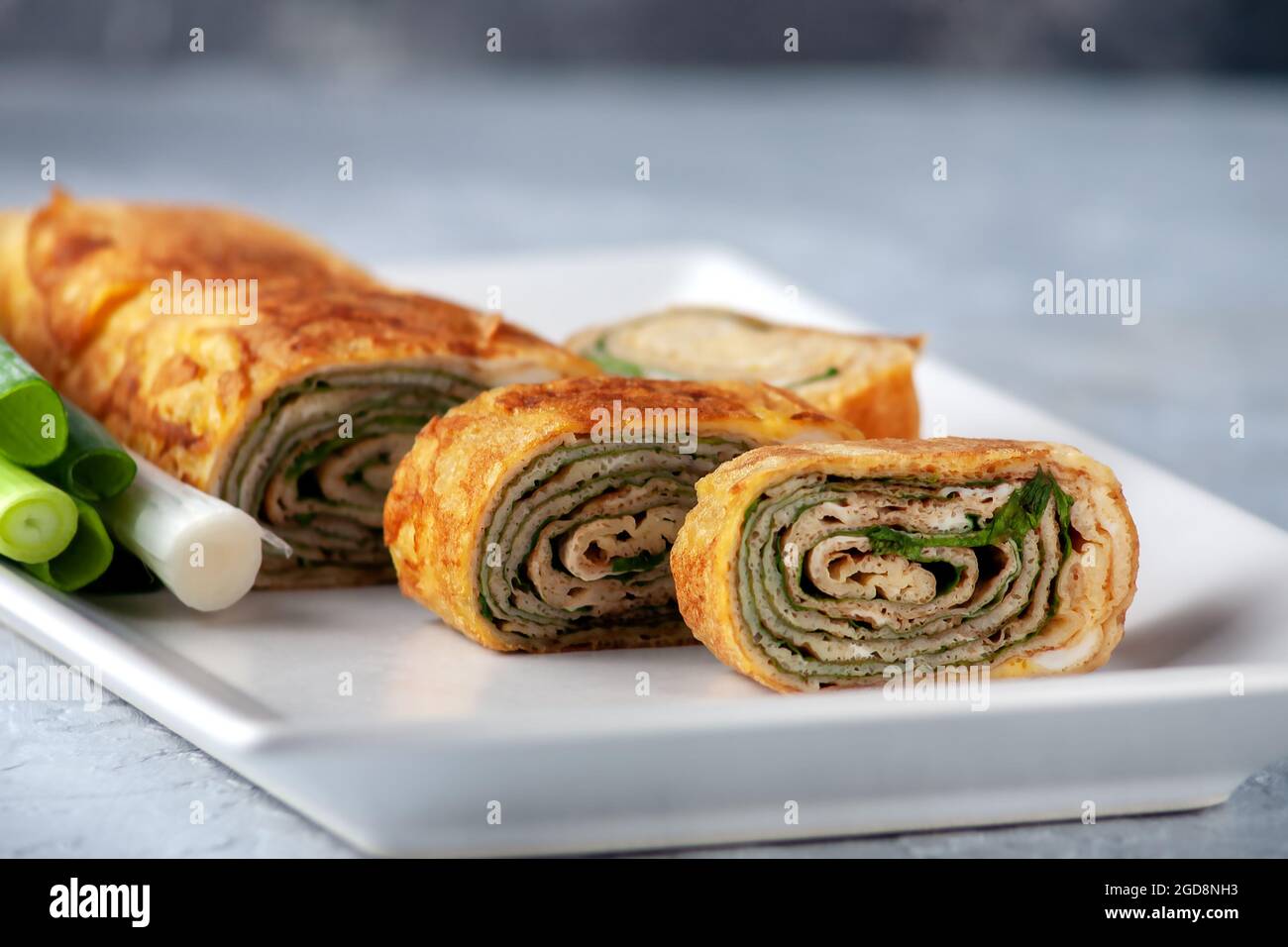 Tamagoyaki - frittata giapponese, arrotolato diversi strati di uova fritte. Cucina giapponese. Foto Stock