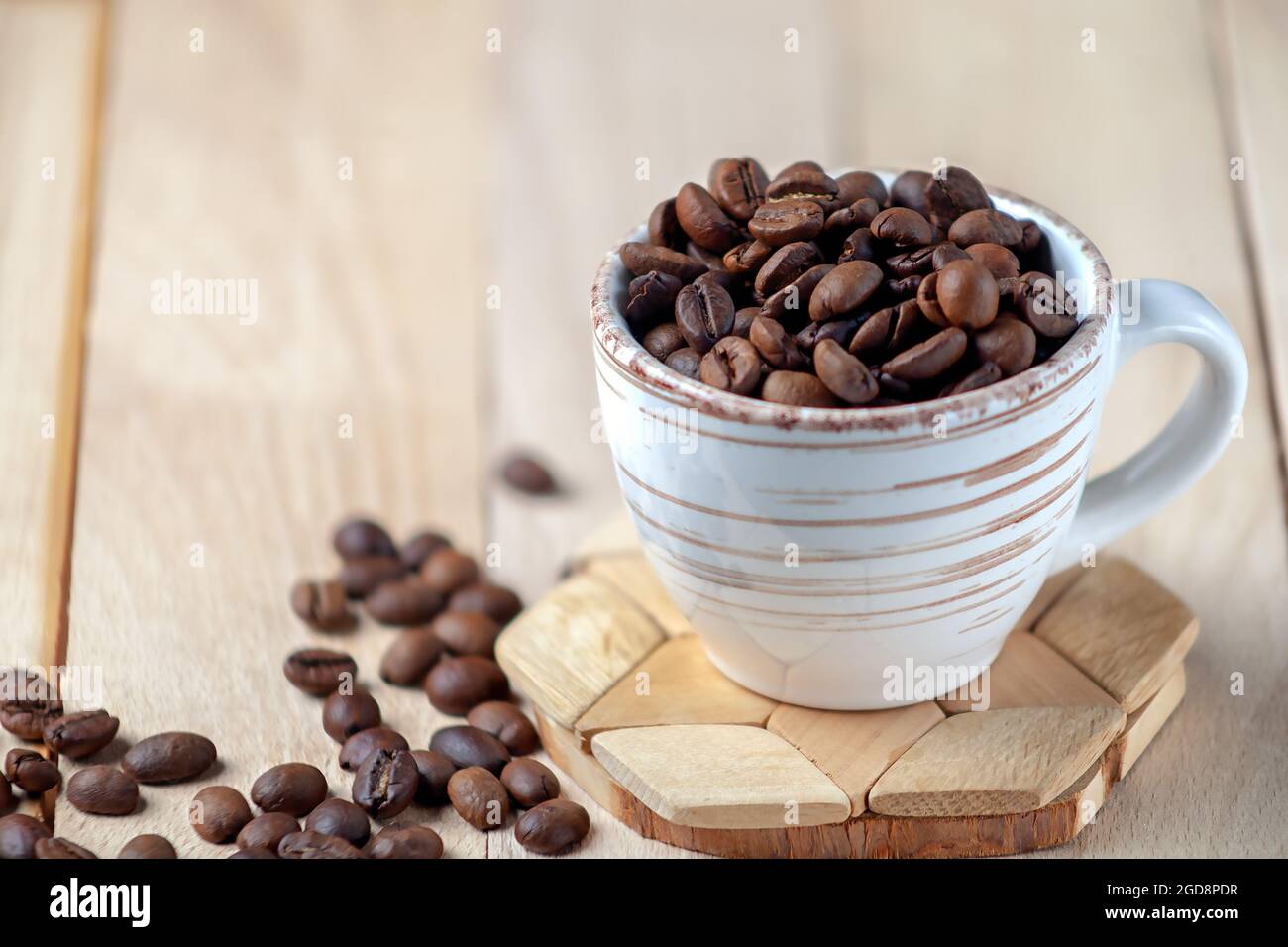 Immagine simbolica del caffè. Chicchi di caffè arrostiti in una tazza di ceramica. Spazio di copia. Foto Stock