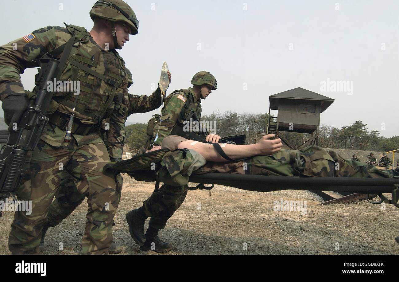 Armati con i loro fucili da assalto M16A2 Colt da 5.56 mm, soldati dell'esercito degli Stati Uniti (USA) del 1° Battaglione, 72nd Armour Regiment spostare un Soldato ferito durante un campo di battaglia simulato al Rodriguez Live Fire Complex, Repubblica di Corea (ROK), a sostegno dell'esercitazione Foal Eagle. (FOTO USAF DI SSGT SUZANNE GIORNO 050323-F-9629D-165) Foto Stock