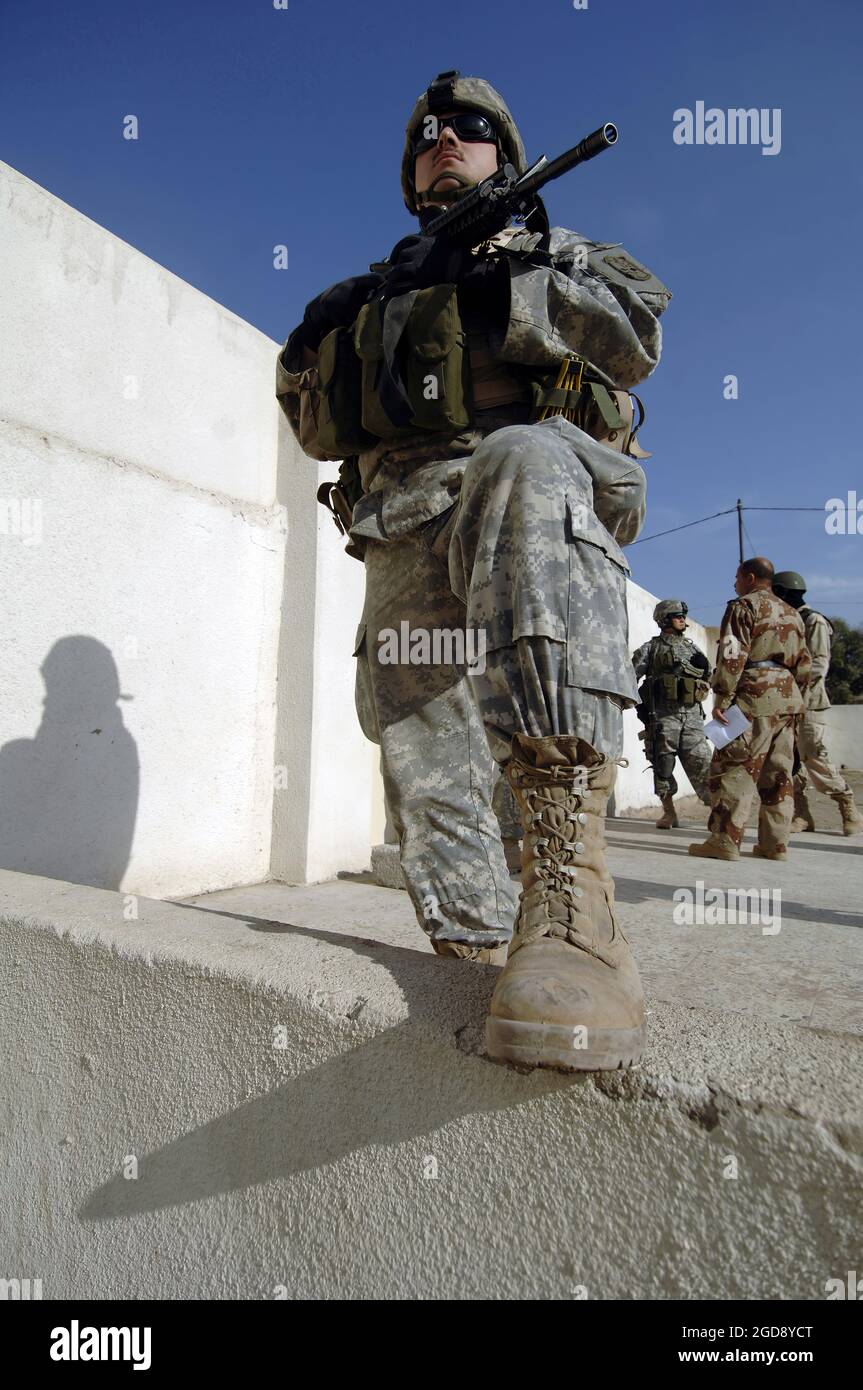 ESERCITO DEGLI STATI UNITI (USA) Sergente (SGT) Chris Carpenter, 2° Battaglione (BN), 1° Reggimento di fanteria (INF REGT), 172° Stryker Brigade Combat Team (SBCT), Fort Wainwright, Alaska (AK), fornisce sicurezza mentre le forze statunitensi e irachene discutono i preparativi per le prossime elezioni a Mosul, Iraq, durante l'operazione DI LIBERTÀ IRACHENA. (FOTO USAF DI SSGT JAMES L. HARPER JR. 051205-F-4177H-119) Foto Stock