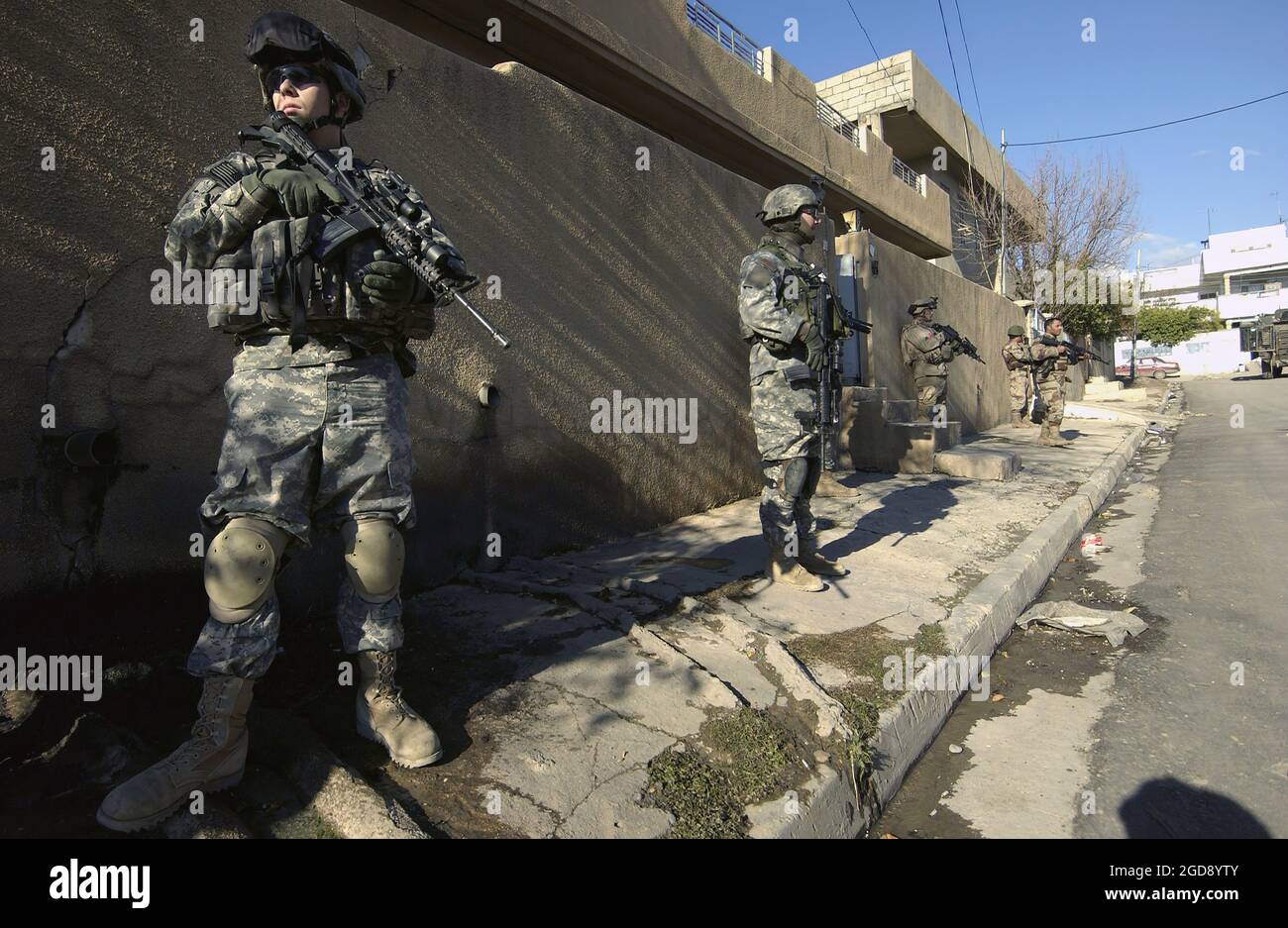 ESERCITO DEGLI STATI UNITI (USA) Specialist Quarta Classe (SPC) Shawn Aiken (sinistra), Alpha Company (A Co), 2nd Battaglione (BN), 1nd Reggimento di fanteria (2nd), 172nd Stryker Brigade Combat Team (SBCT), fornisce sicurezza durante una pattuglia militare congiunta degli Stati Uniti e dell'esercito iracheno (IA) attraverso un quartiere a Mosul, provincia di Ninawa, Iraq (IRQ) Durante l'operazione LA LIBERTÀ IRACHENA. (FOTO USAF DI TSGT JOHN M. FOSTER 060121-F-2869F-004) Foto Stock