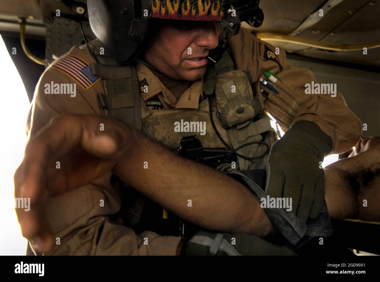 US Army (USA) staff Sergeant (SSG) David Edens, Aerial Combat Medic, 1st Forward Support Medical Team (FSMT), avvolge un monitor della pressione sanguigna intorno a un braccio ferito del soldato iracheno durante una missione di evacuazione medica (MEDIVAC) vicino a Tall Afar, Iraq (IRQ). USA SSG Edens schierato dalla 542nd Medical Company (Air Ambulance) (MED CO (AA)), Fort Campbell, Kentucky (KY), a sostegno dell'operazione DI LIBERTÀ IRACHENA. (FOTO USAF DI SSGT JACOB N. BAILEY 060717-F-5964B-078) Foto Stock