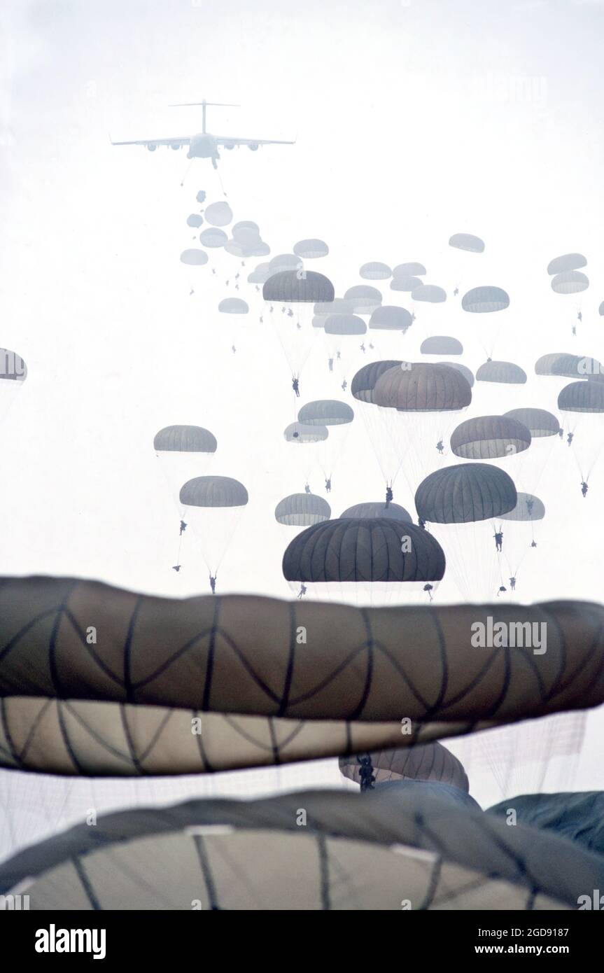 Vista posteriore lungo scatto di un USAF C-17 Globemaster III come USA Army Airborne truppe cadere dal retro. Paracadute paracadutismo sono viste in tutto il primo piano fino allo sfondo. Questa immagine è tratta dall'edizione di gennaio 1999 di Airman Magazine che mette in evidenza la Expeditionary Aerospace Force. (FOTO USAF DI MSGT VAL GEMPIS 990101-F-0943S-007) Foto Stock