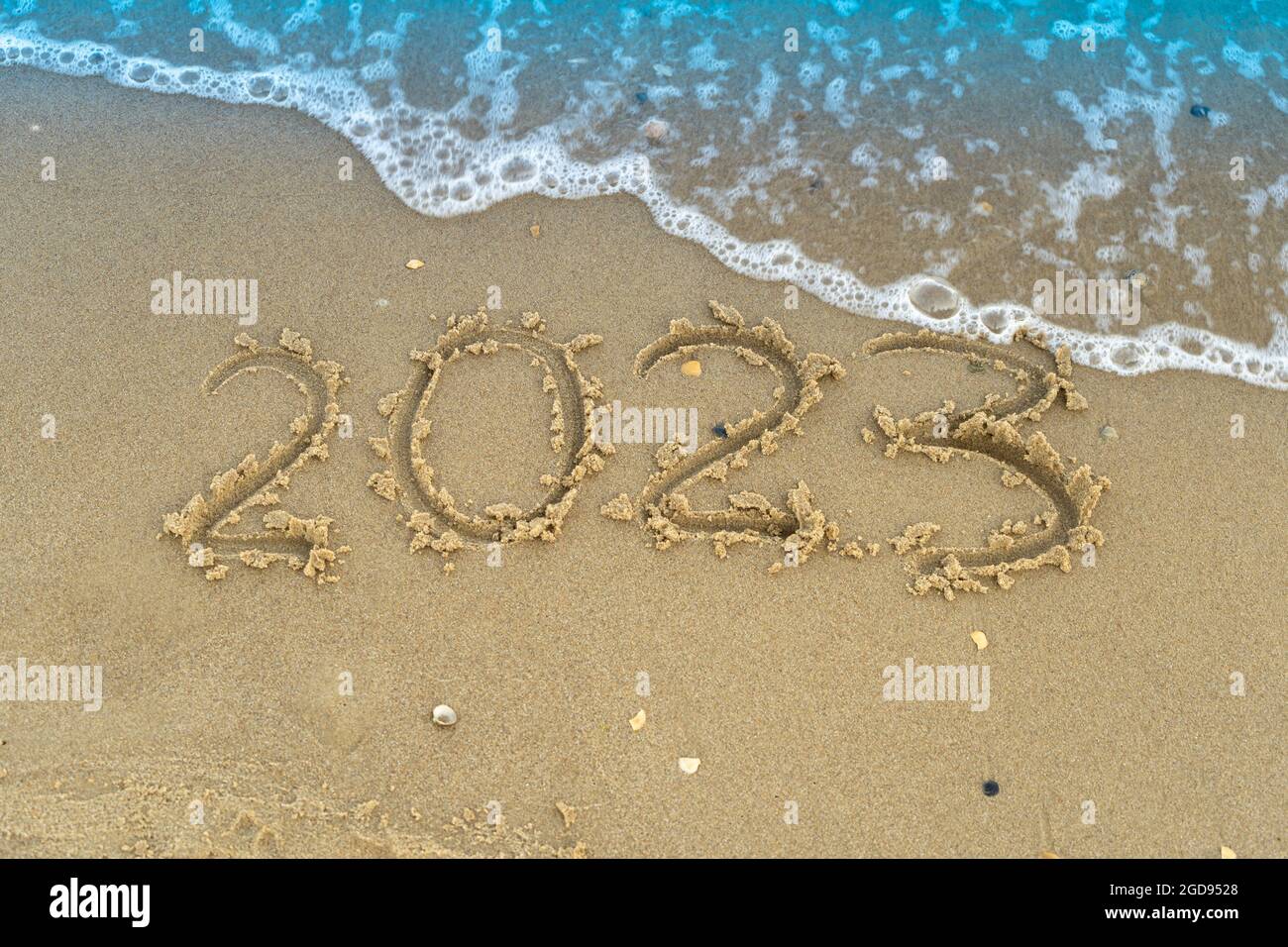 I numeri 2023 sono scritti su una spiaggia di sabbia. Onde e surf. Capodanno estivo. Vacanza, resort e ricreazione. Natura. Mare costa Foto Stock