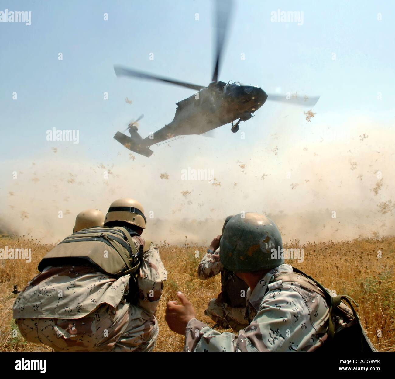 Soldati dell'esercito iracheno del 3° Battaglione (BN) 3° Brigata (BDE) 5° Divisione dell'esercito iracheno (IAD) si stringono e si preparano ad avvicinarsi ad un elicottero dell'esercito statunitense (USA) UH-60 Blackhawk (Black Hawk) che li trasferirà da un villaggio vicino a Mujahida City, Iraq (IRQ). (FOTO BLU MARINO DI MC1 JACKEY BRATT 060816-N-4097B-032) Foto Stock