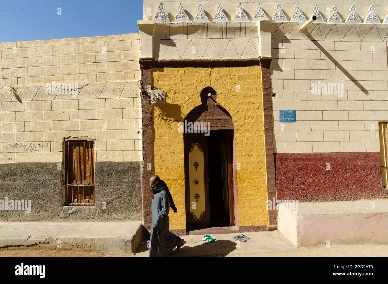 Assuan Egitto. 10 Gennaio 2013 uomo musulmano nubiano che lascia una Moschea dai colori vivaci sull'Isola Elefantina sul fiume Nilo ad Assuan, nell'Alto Egitto Foto Stock