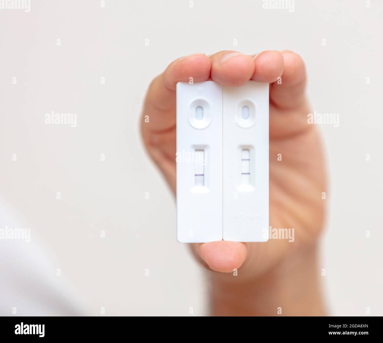 Mano dell'uomo con covid 19 risultati positivi e negativi test rapidi, kit per la rilevazione di anticorpi. Test di auto coronavirus a casa, infezione e immun Foto Stock