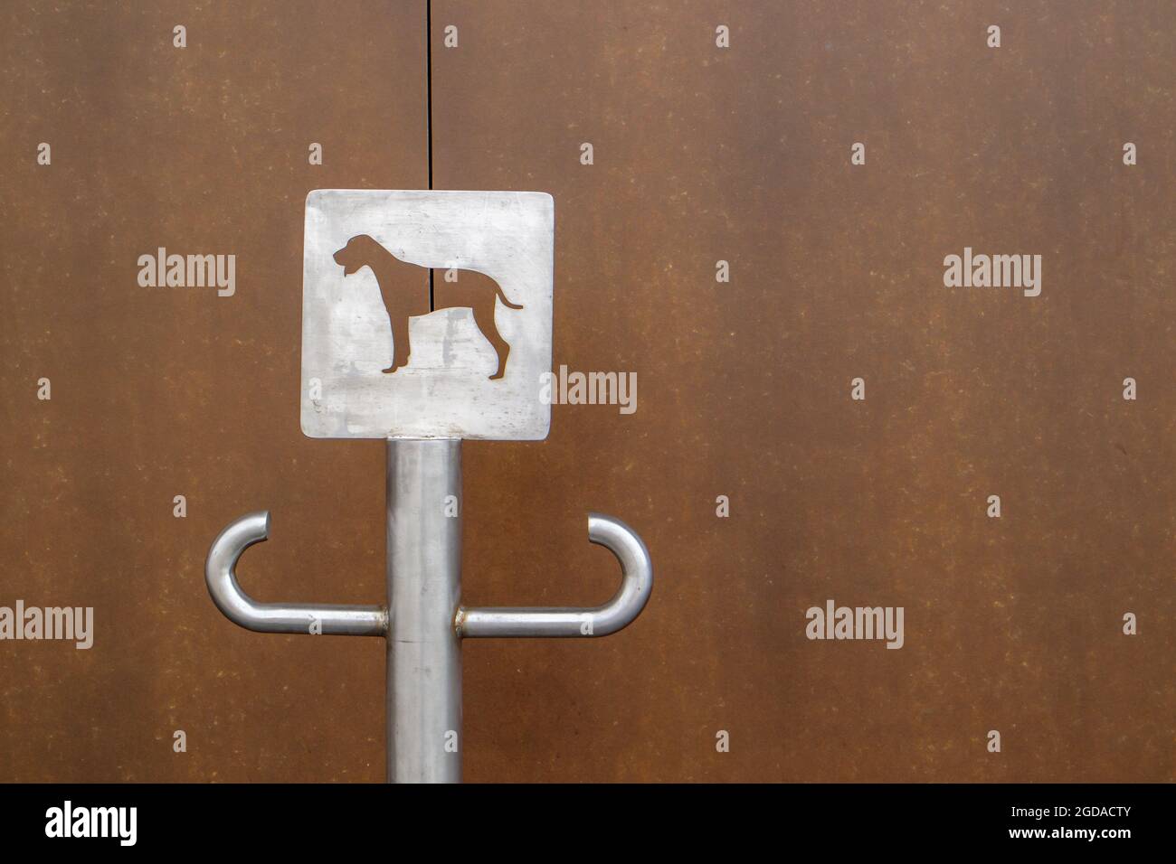 Primo piano di un cartello per il parcheggio all'aperto per cani. Un posto per un guinzaglio per i cani in attesa dei loro proprietari sulla strada. Fissare un guinzaglio, in luoghi pubblici o a t. Foto Stock