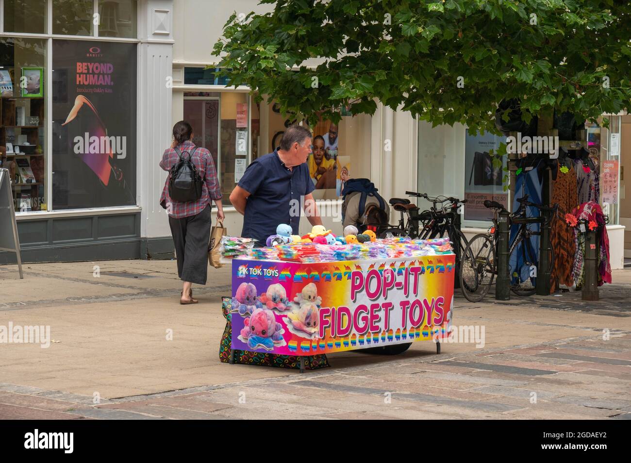 Commerciante di mercato di strada che vende i giocattoli Fidget Spinner Fidget Fidget Pop IT nel centro di norwich City Foto Stock